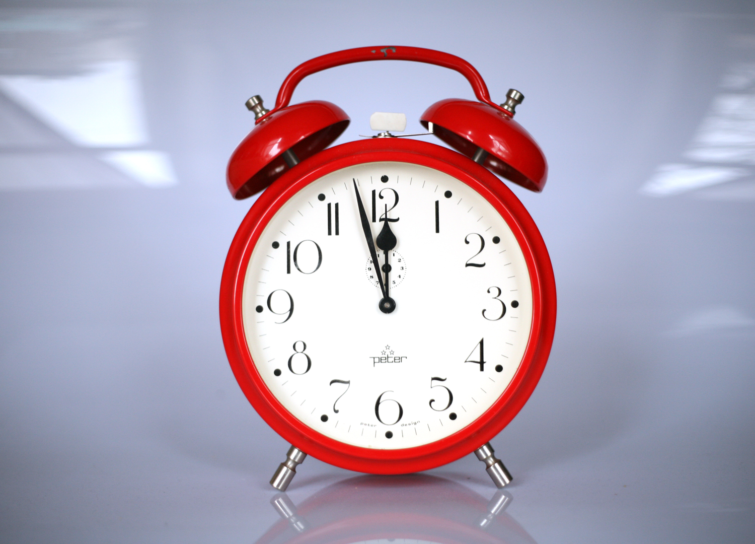 A red clock showing time: almost midnight