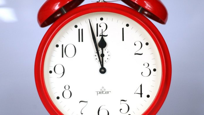 A red clock showing time: almost midnight